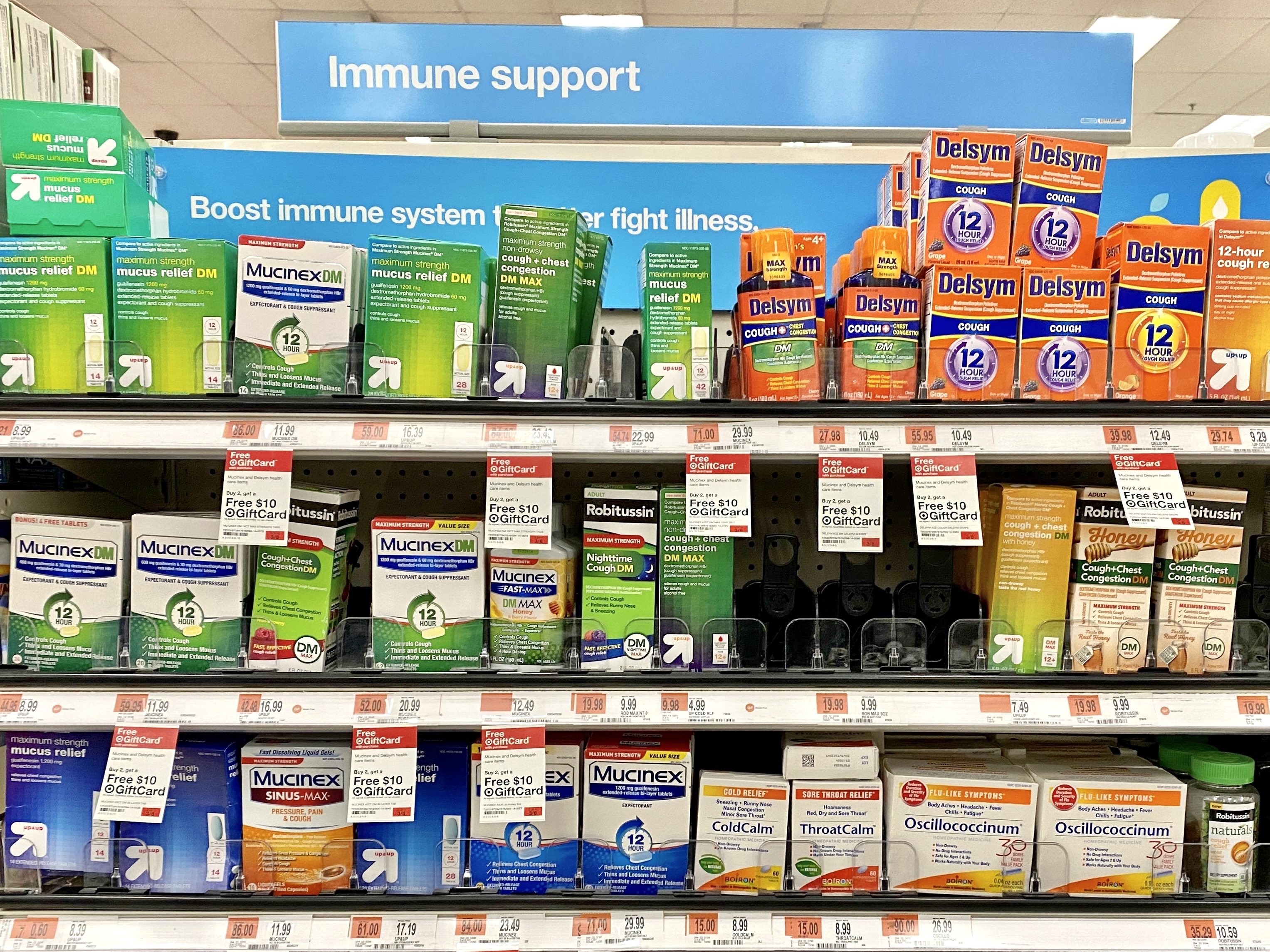 Drug store aisle with Mucinex and Robitussin next to homeopathic cold calm, throat calm, and Oscillococcinum.